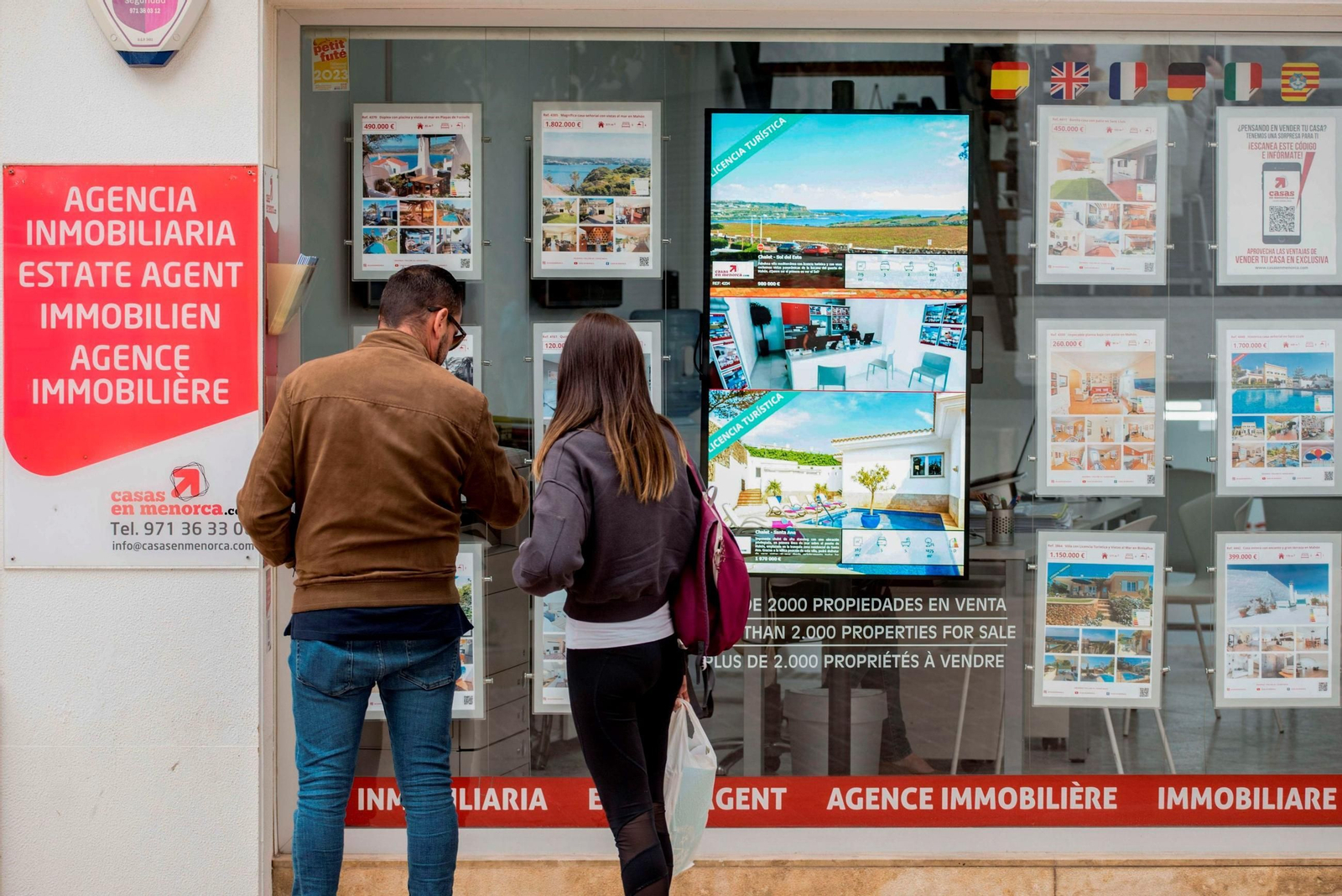 Una pareja frente a una inmobiliaria. Una pareja frente a una inmobiliaria.