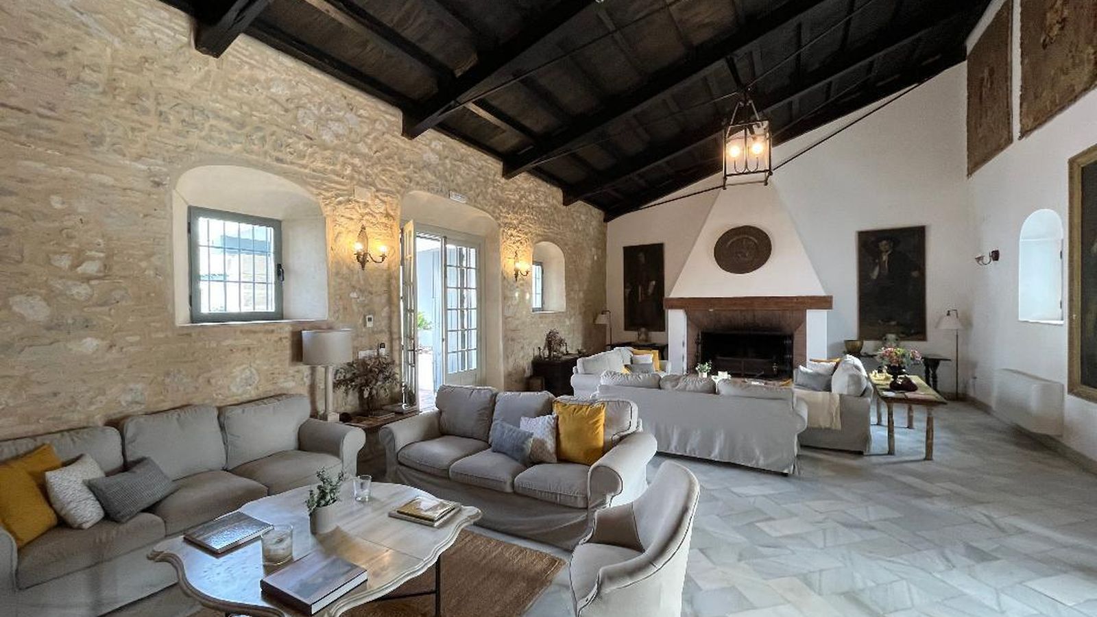 En el fondo del salón, una gran chimenea de ladrillos junto a dos mesas de San Antonio.