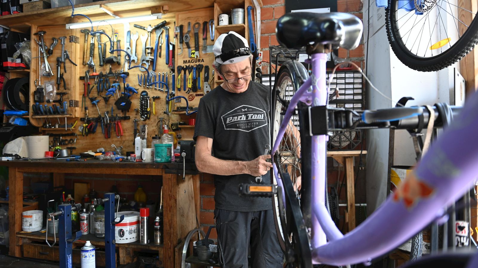 Gregory Mills, propietario de Recyclo Bikeshop, arregla una bicicleta en el taller con el que también cuenta la tienda.