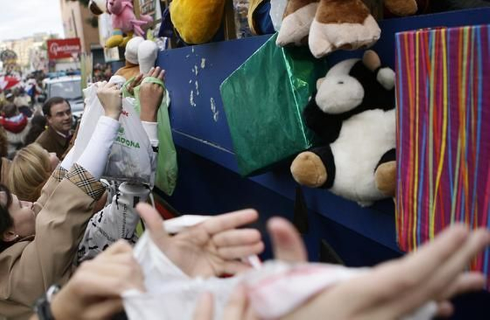 Los sevillanos se acercan a las carrozas con bolsas de plástico para conseguir más cantidad de caramelos.

Foto: Antonio Pizarro