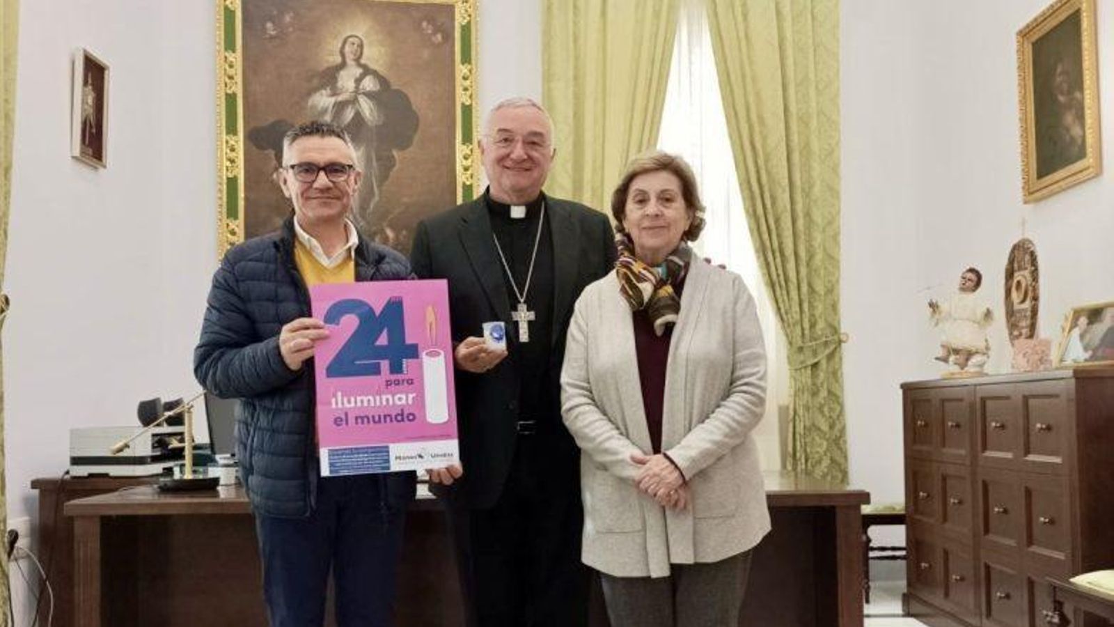 El obispo de Almería, Antonio Gómez Cantero, con la vela de Manos Unidas.