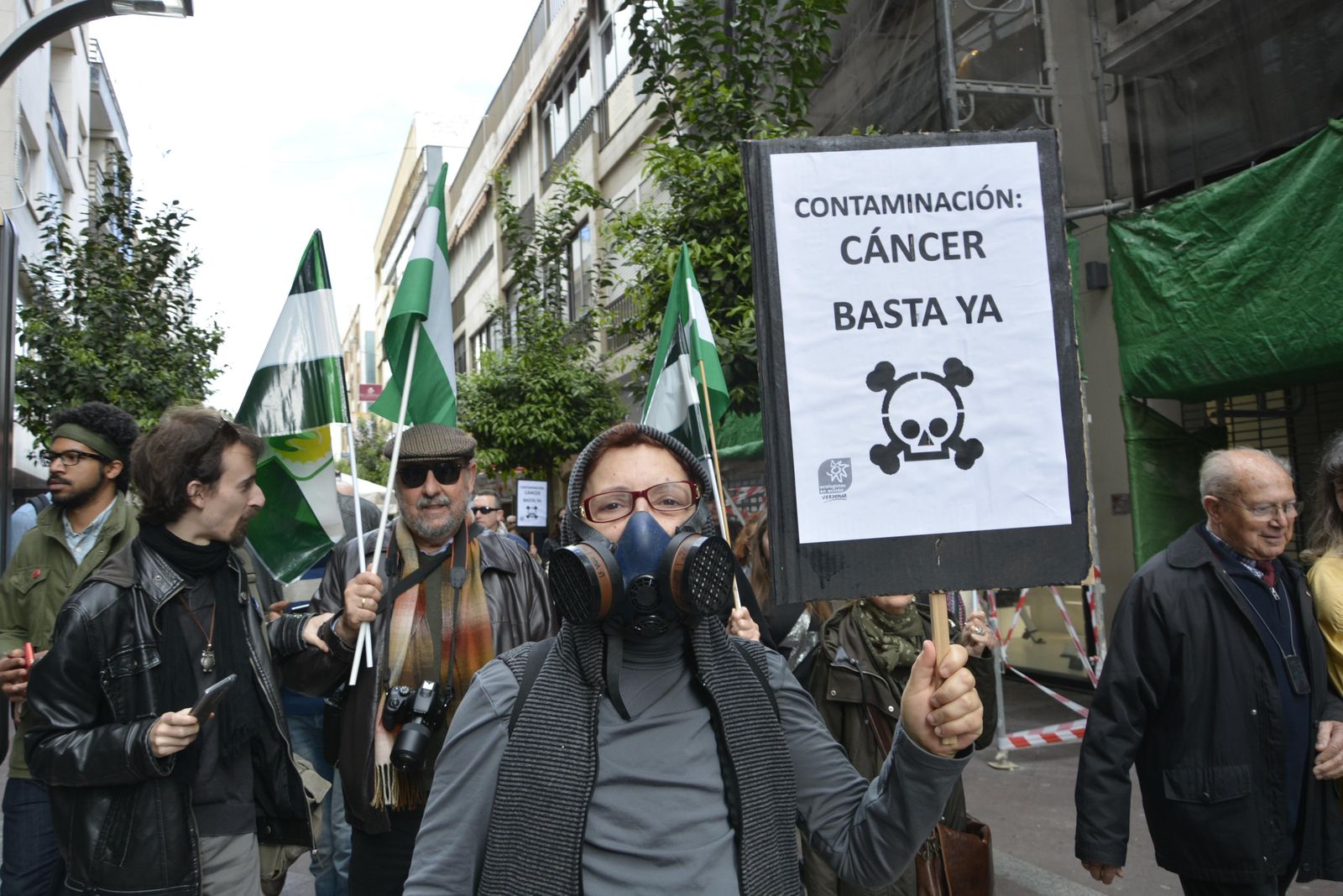 Una mujer porta una pancarta contra la contaminación.