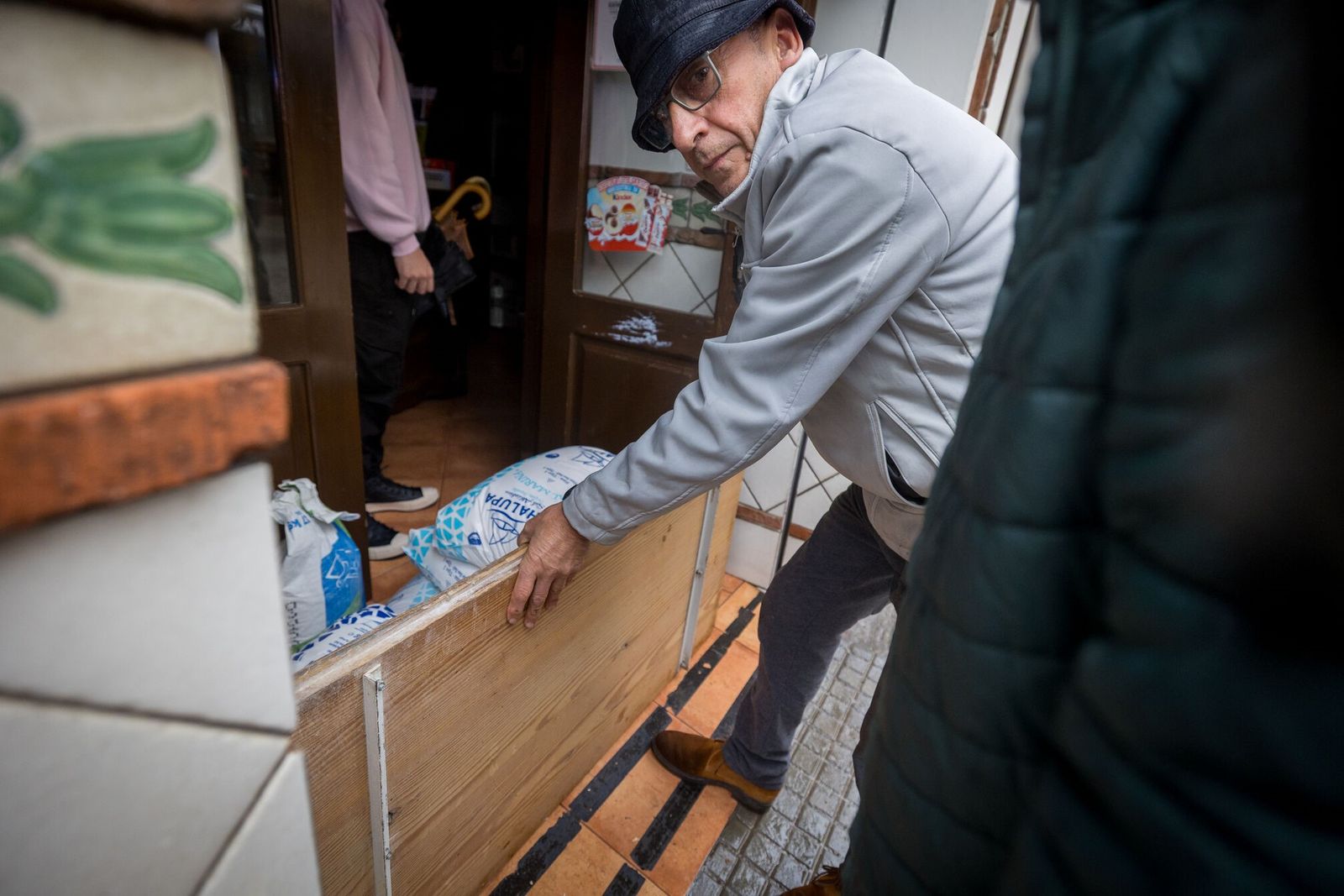 Un vecino asegura su negocio ante la subida del río Ubrique.