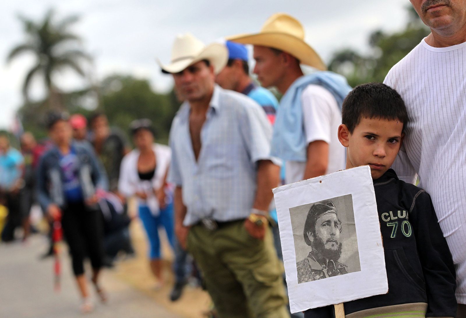 Un niño sostiene una foto de Fidel Castro, mientras miles de cubanos esperaban el paso de la caravana con sus cenizas.