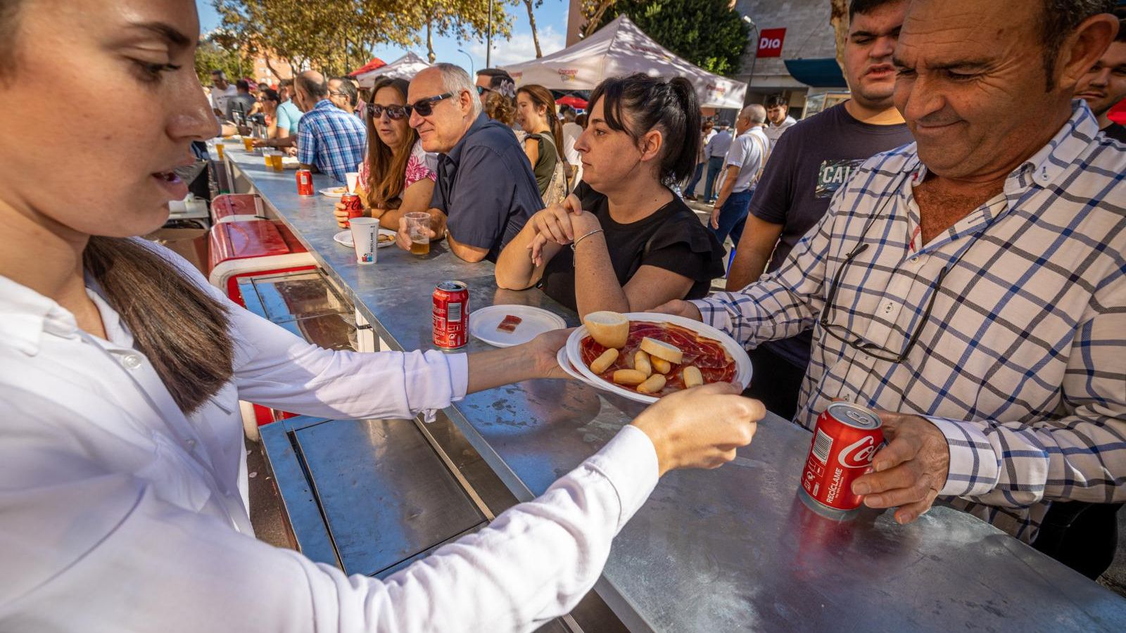 Despachando raciones de jamón en la Feria Solidaria de Cortadores celebrada en San Fernando.