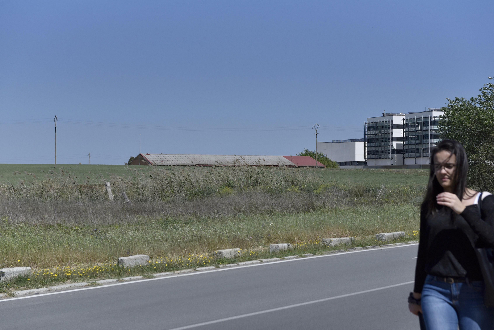 Una joven camina junto a la parcela dela Olavide en la que se levantará la sede de Toxicología.