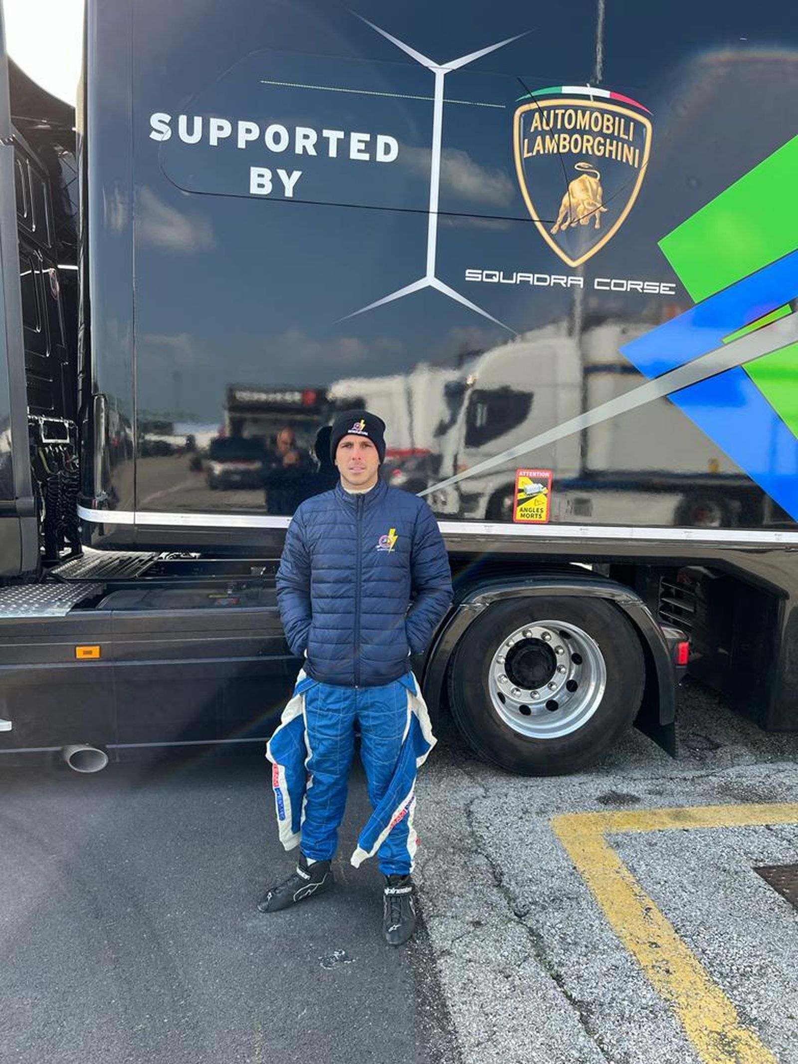 Manu Bejarano posa ante uno de los camiones de Lamborghini.