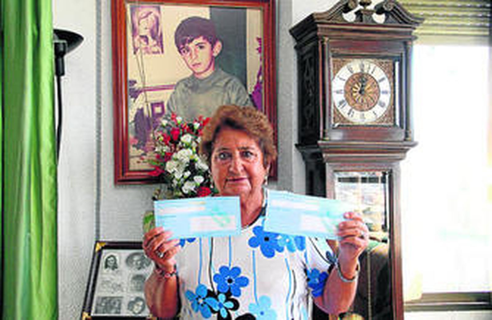 Isabel García con los recibos de los impuestos ante la foto de su hijo.