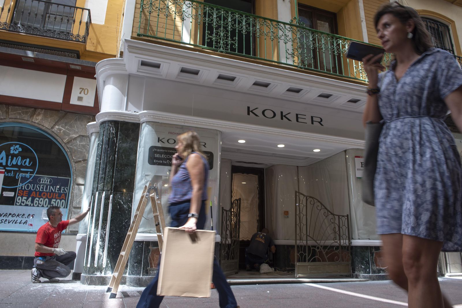 Un operario quita la pintura blanca del mármol de la fachada de la antigua Joyería Ruiz.