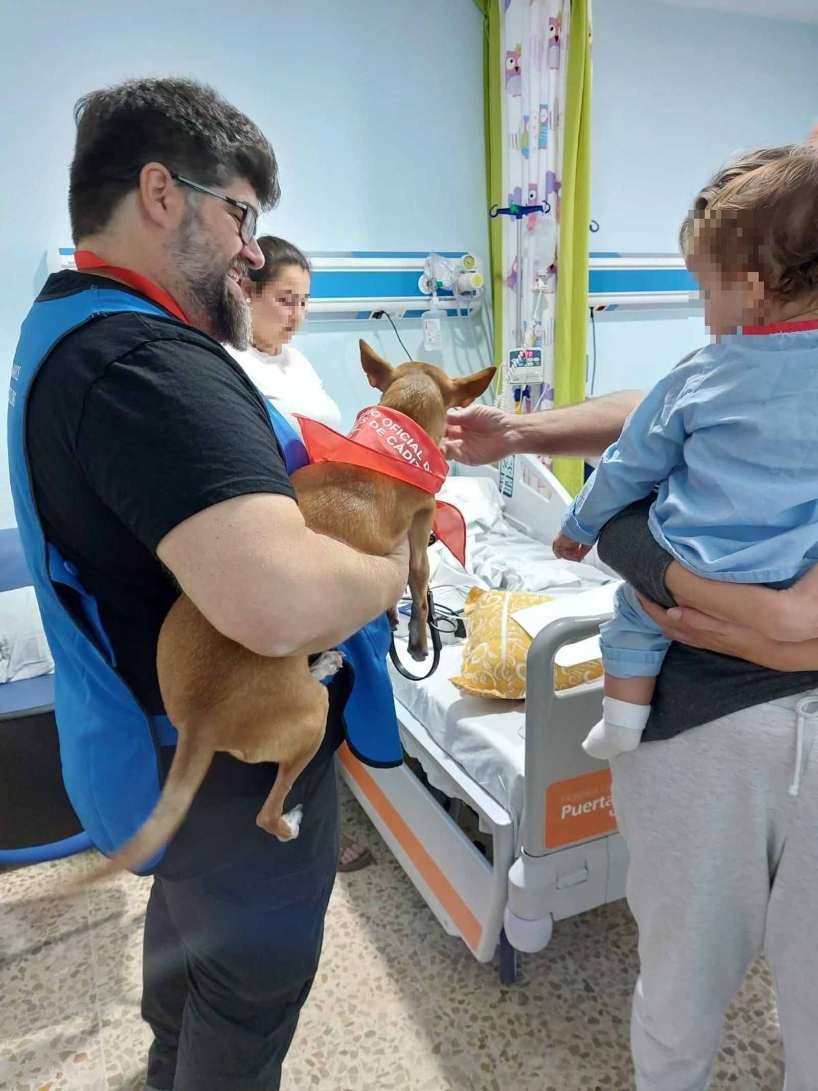 Rubén Marqués, veterinario colegiado y voluntario de COLVET, con su perro 'Café', durante una visita a pacientes del Puerta del Mar.