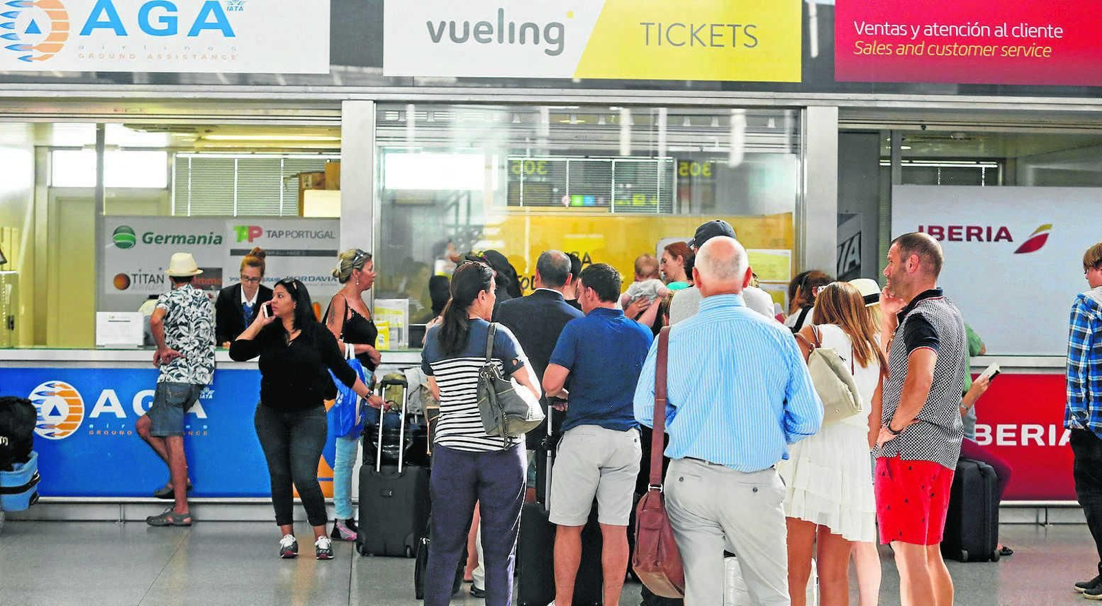 Cola de pasajeros de Vueling frente a un mostrador de atención al cliente