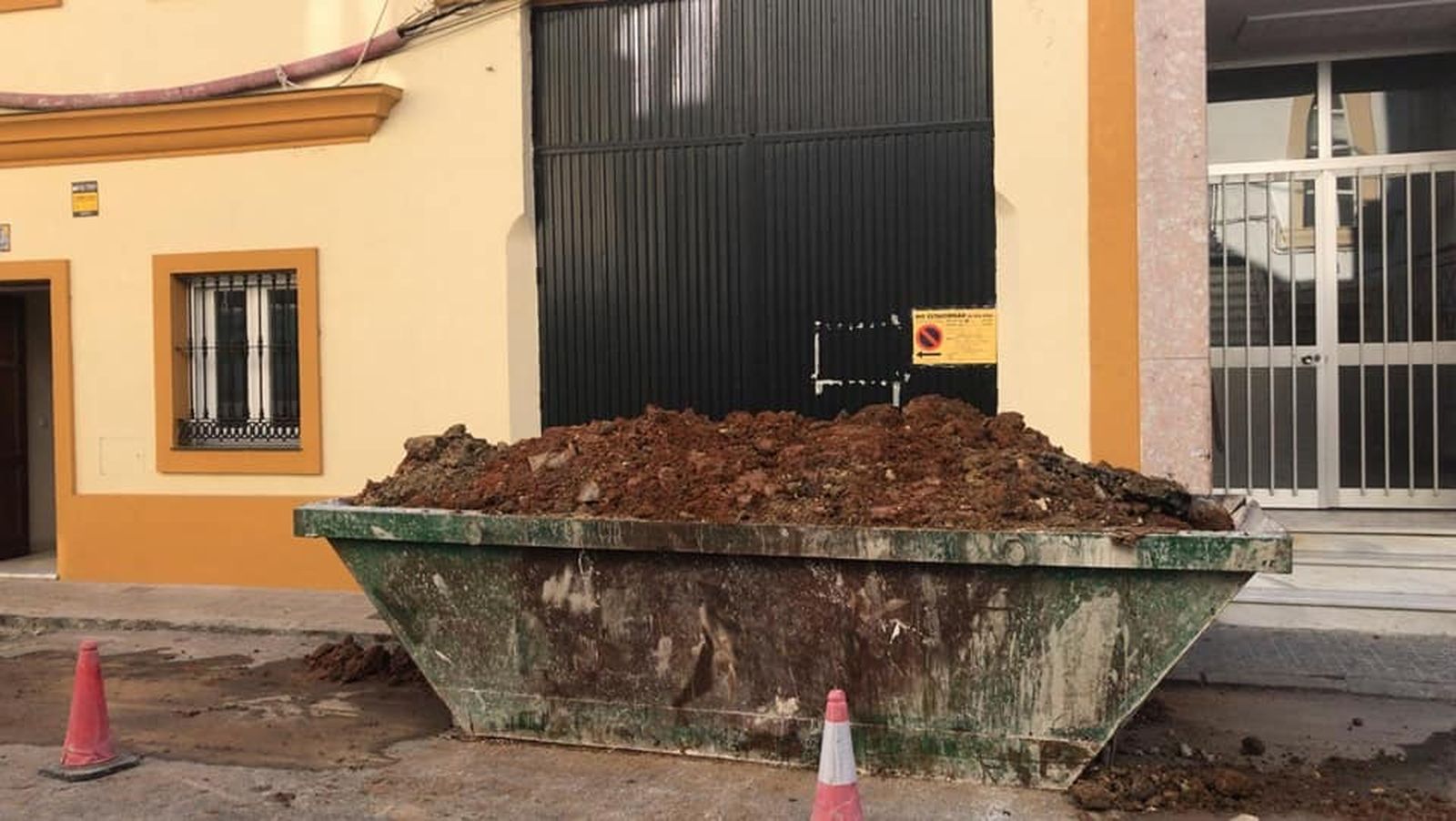 Trabajos y cuba para los escombros colocada a la misma puerta de la casa de hermandad del Huerto, por donde salen los pasos.