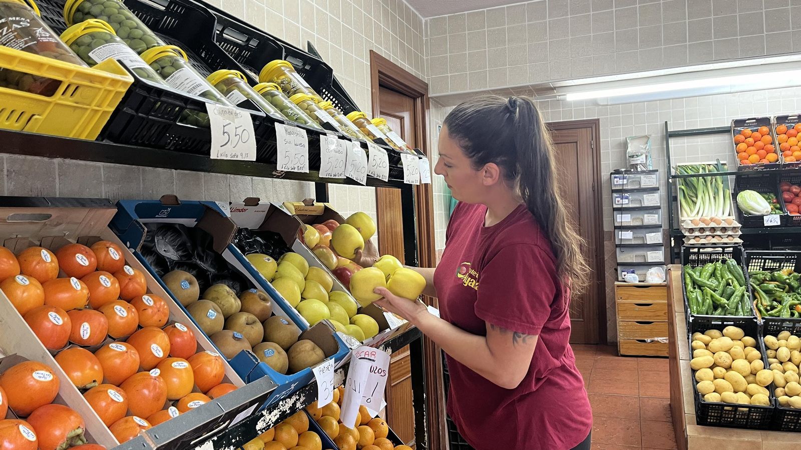 Ayala coloca algunas frutas en sus cajas.