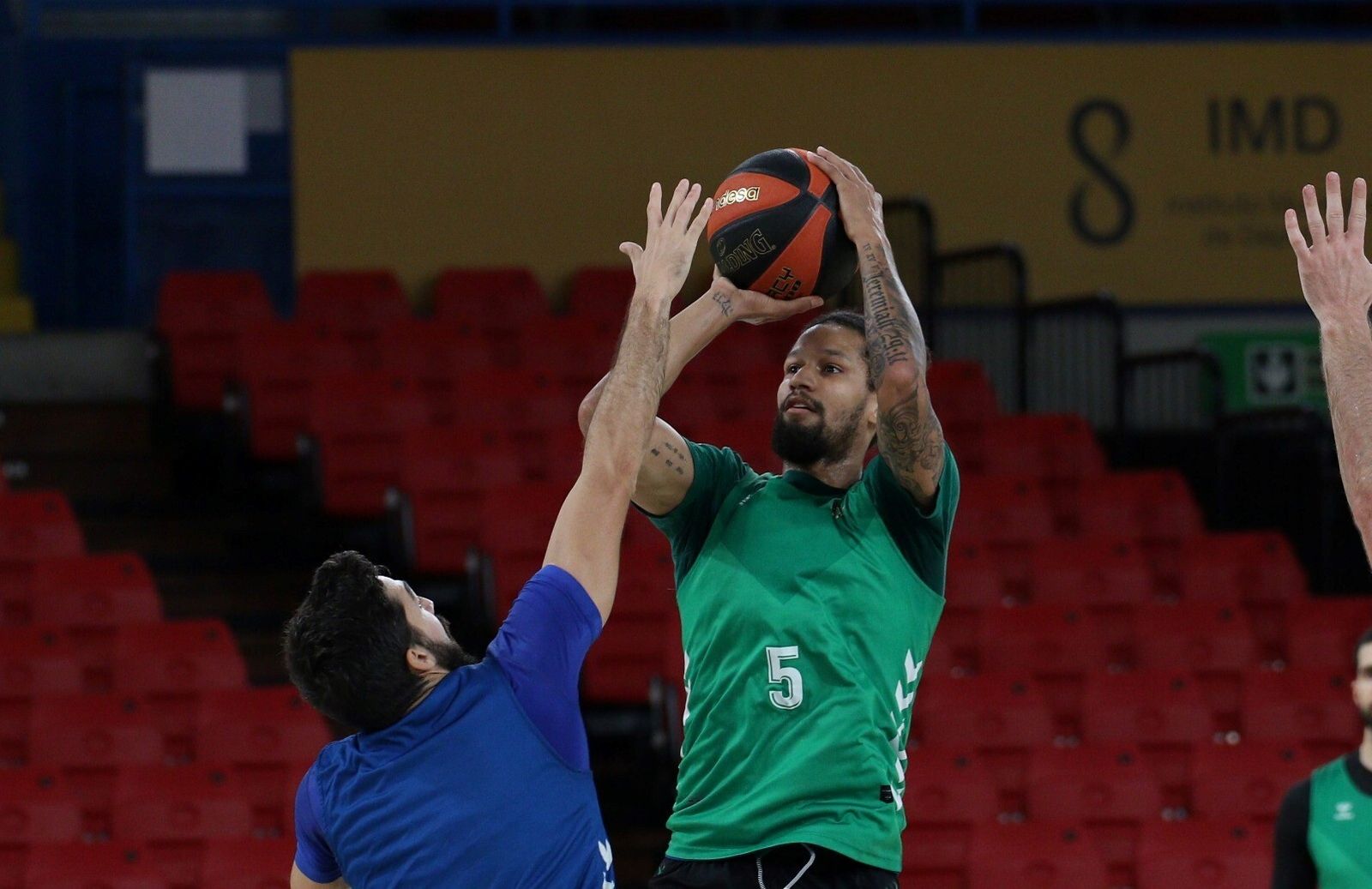 Jeremiah Hill lanza a canasta por encima de Pepe Pozas en un entrenamiento.