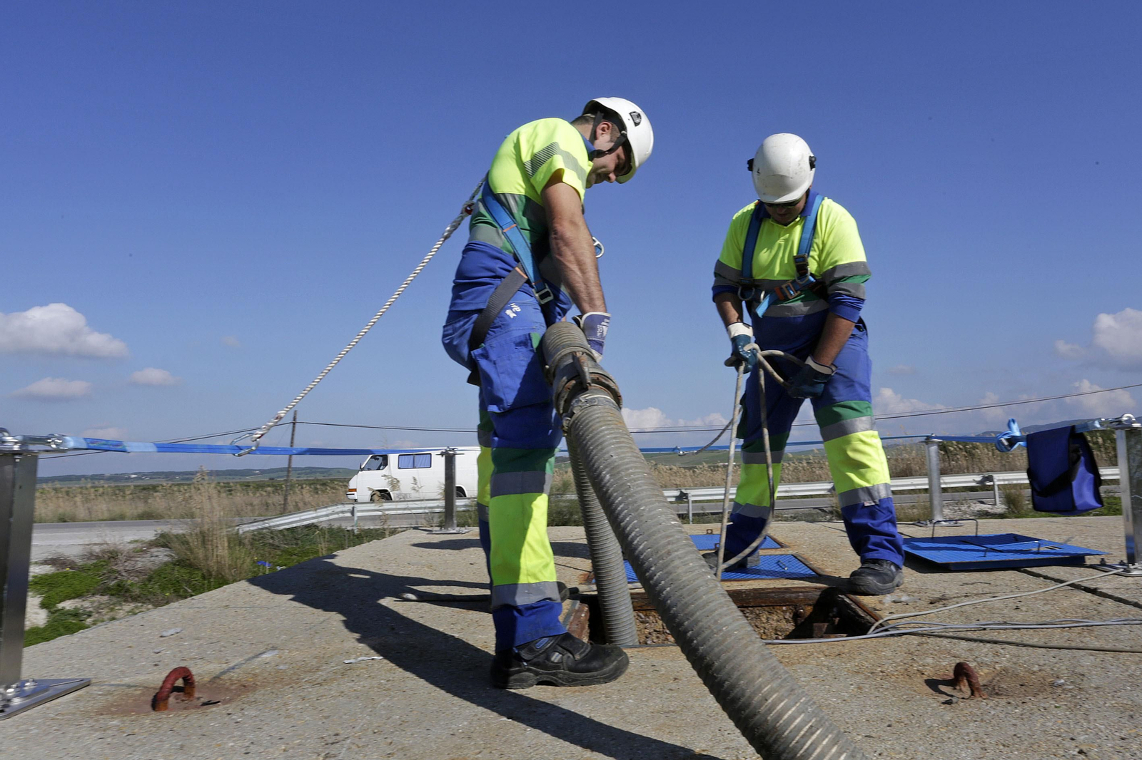 Imagen de archivo de dos trabajadores de Aqualia limpiando en la depuradora de Barbate la fosa a la que llegan los residuos de Zahara de los Atunes.