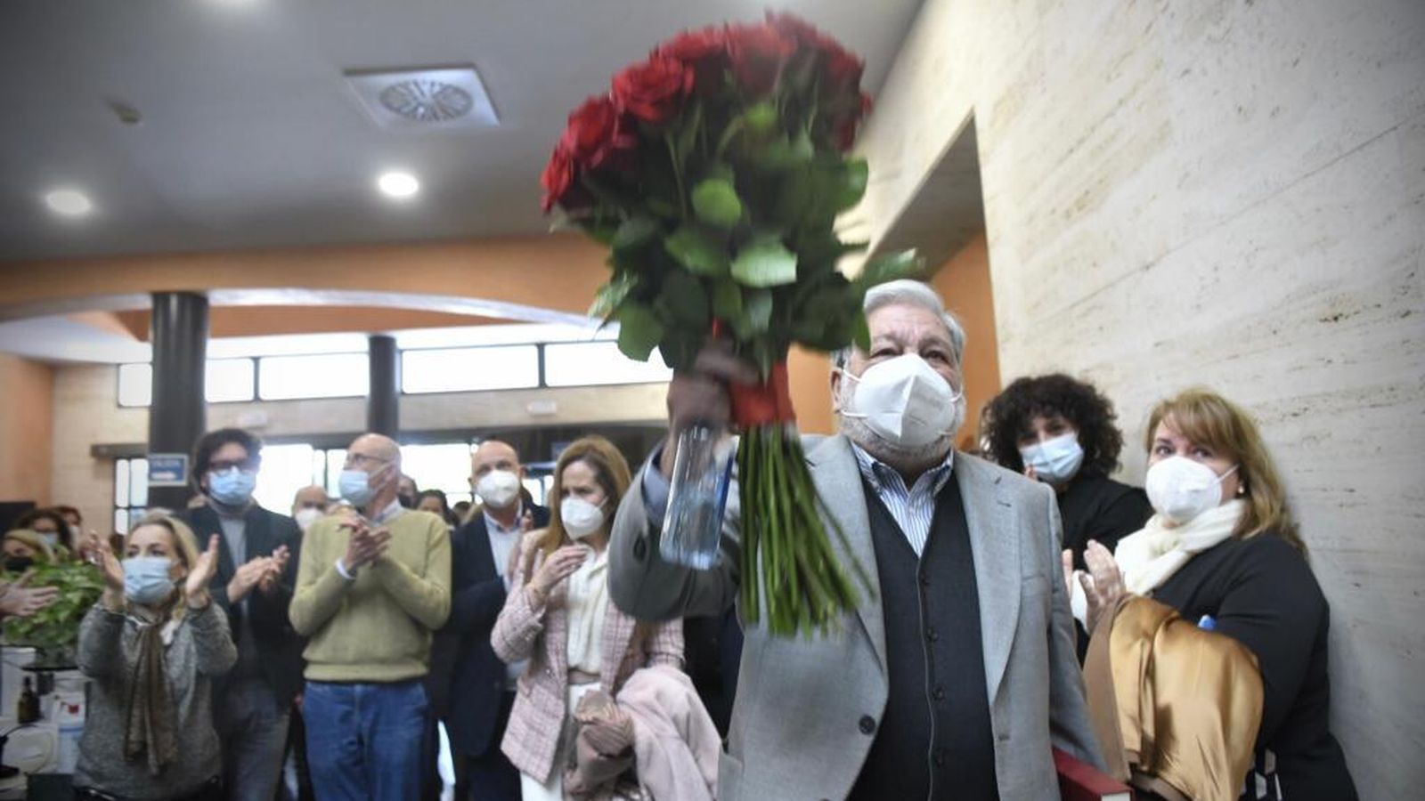 Toscano muestra el ramo de rojas recibido a la salida del pleno de renuncia.
