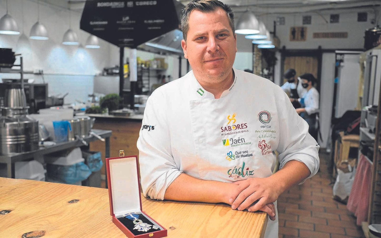 El cocinero junto a la medalla que recientemente de otorgó la Casa Real por su labor solidaria.