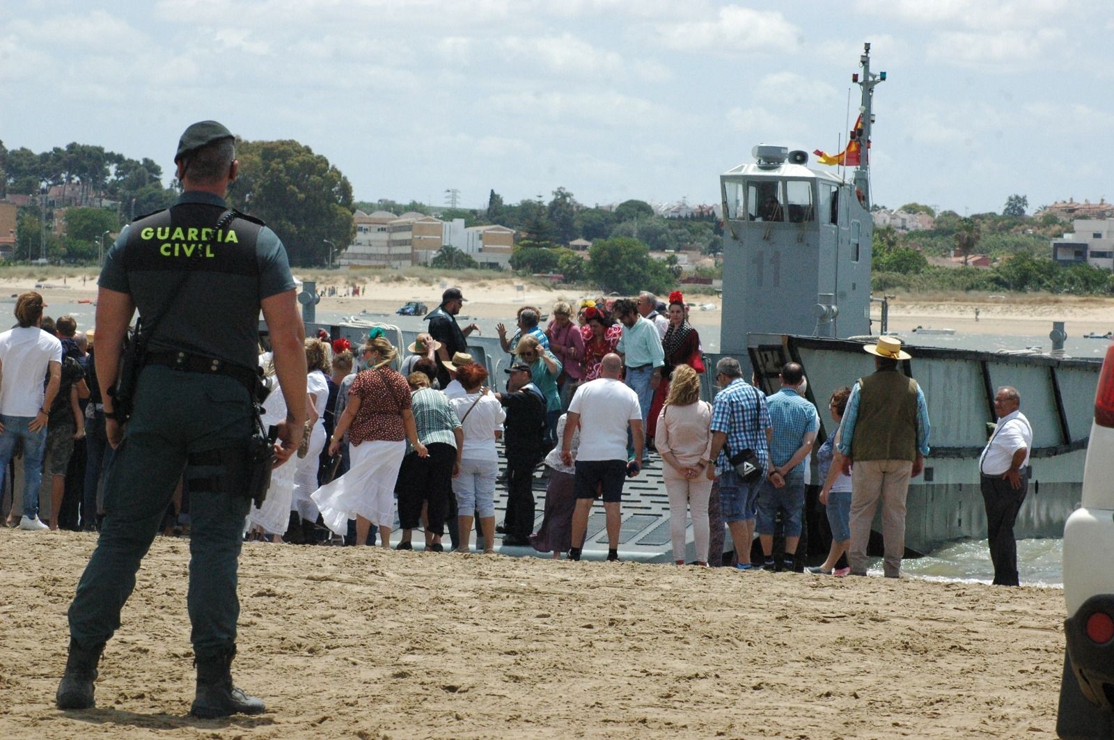 Un agente vigila el desembarco de peregrinos en la Punta de Malandar, ayer.