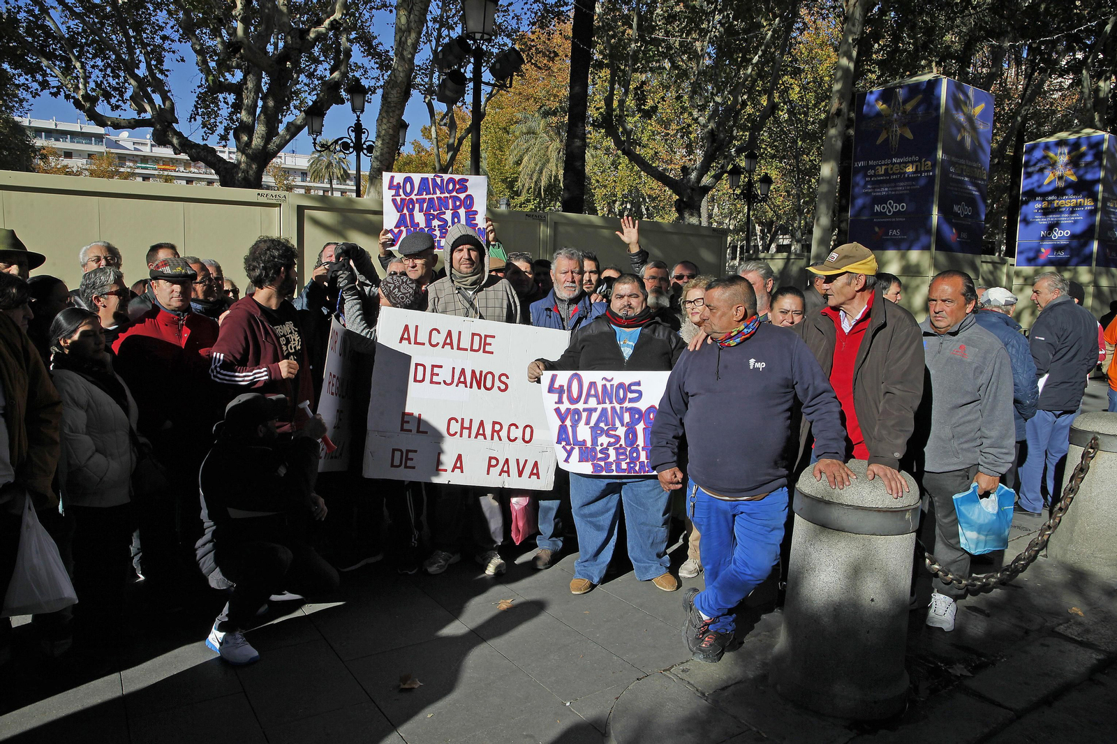 Vendedores del mercadillo del domingo del Charco de la Pava en la Plaza Nueva con pancartas.