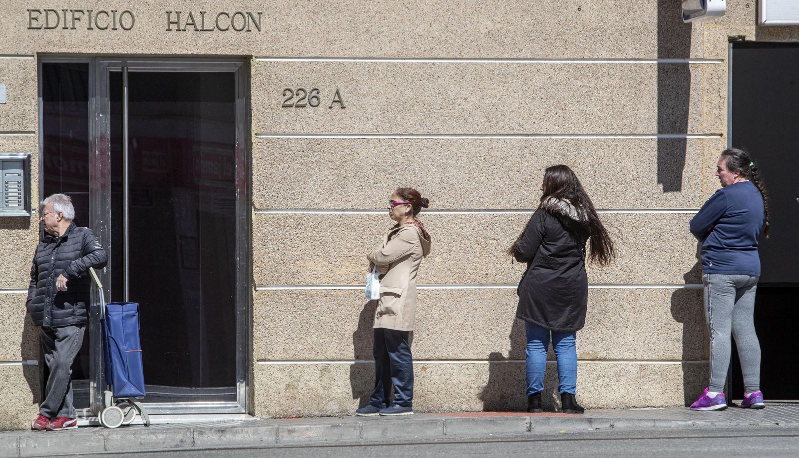 Personas aguardando la cola en un supermercado.