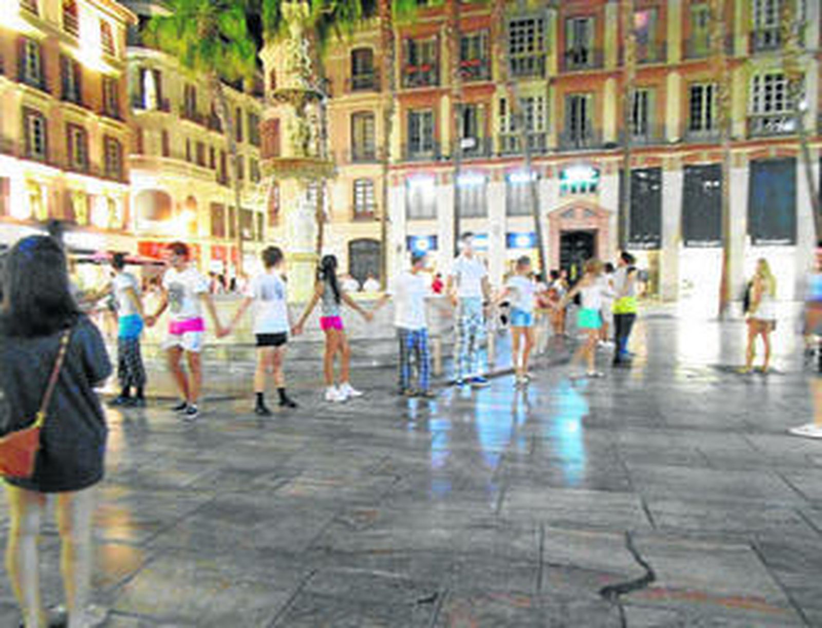 Novatos bailando el corro de la patata en la Plaza de la Constitución bajo la vigilancia de veteranos.