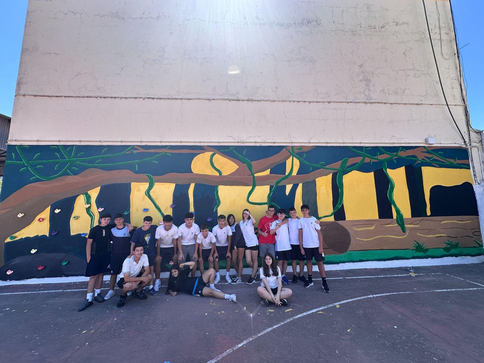 El alumnado ante el mural realizado en una pared del colegio Villoslada.