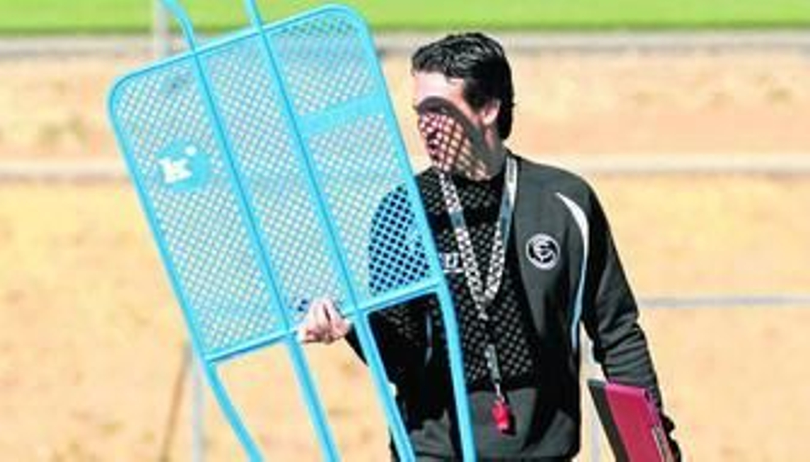 Unai Emery sostiene una barrera con una mano y su carpeta con la otra durante un entrenamiento.
