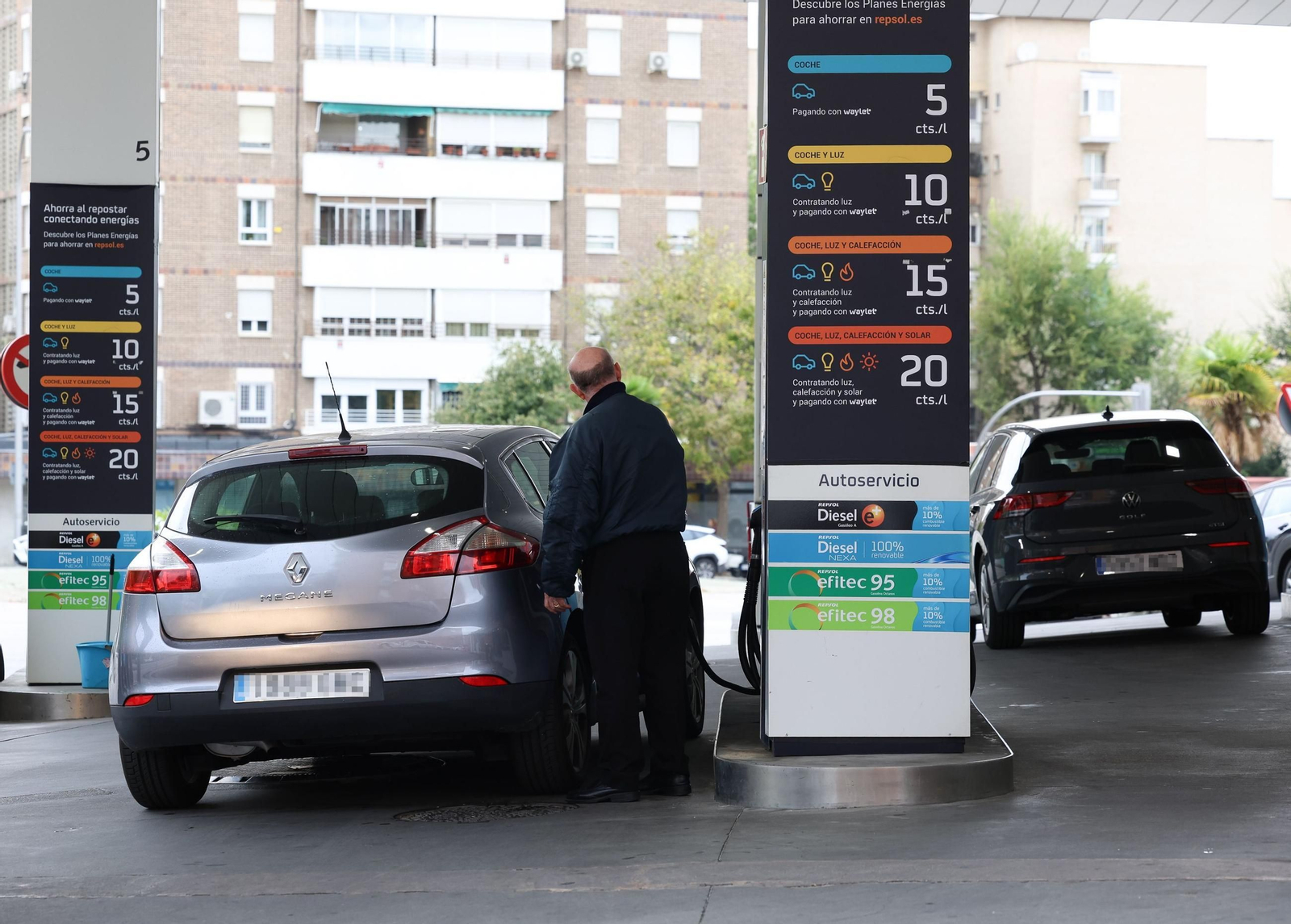Un señor repostando en una gasolinera.
