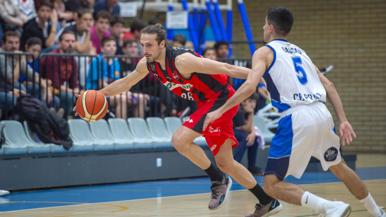 Carlos de Cobos trata de superar a un defensor del CB Prat.