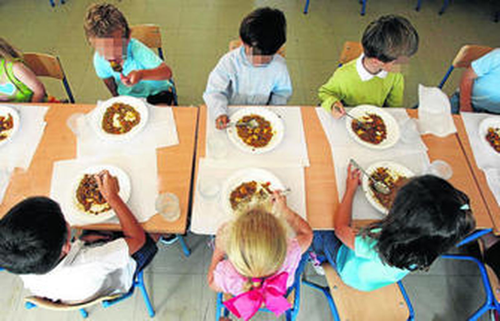 Un grupo de niños en un comedor escolar.