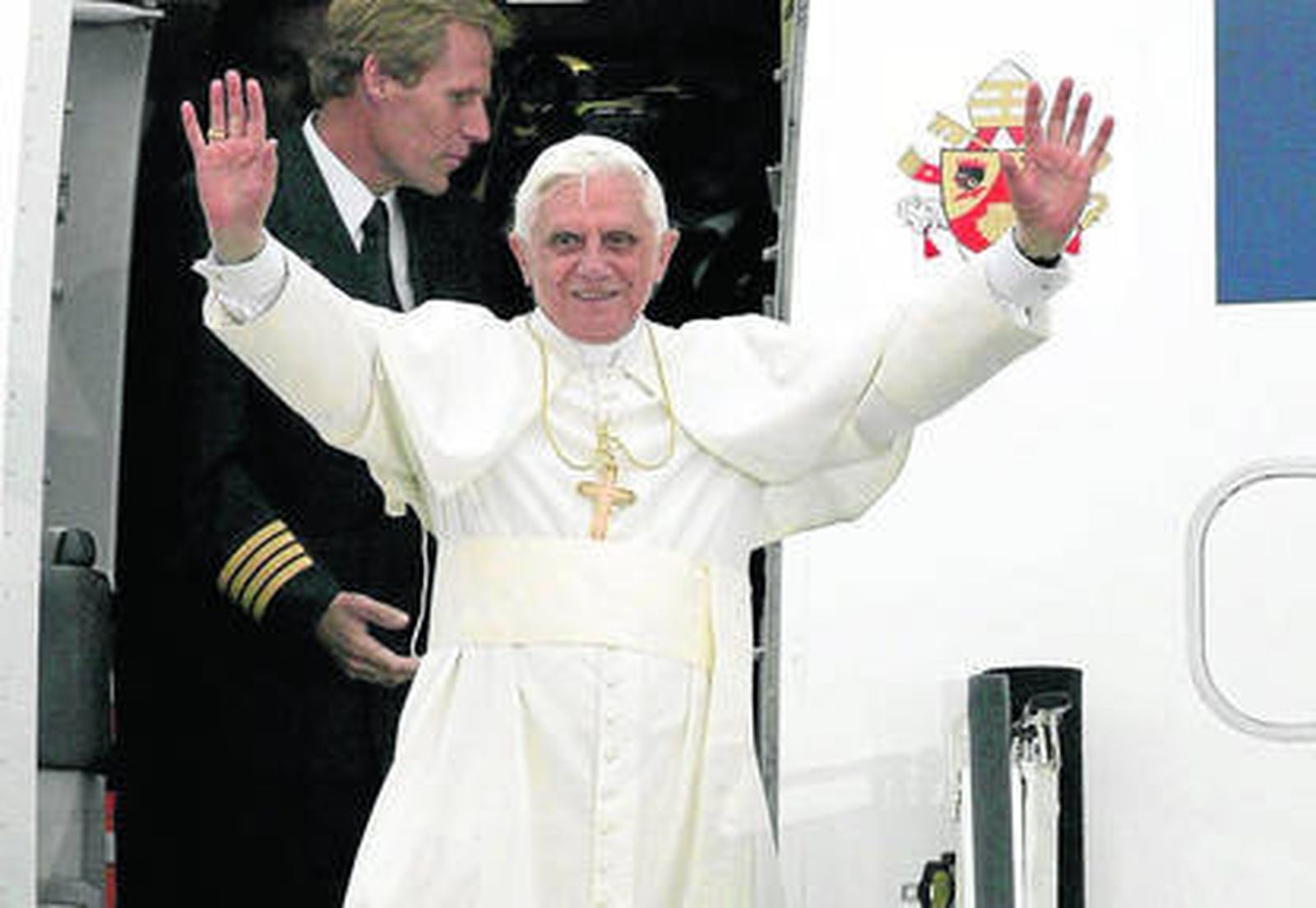 Benedicto XVI saluda desde el avión en uno de sus viajes por el mundo.