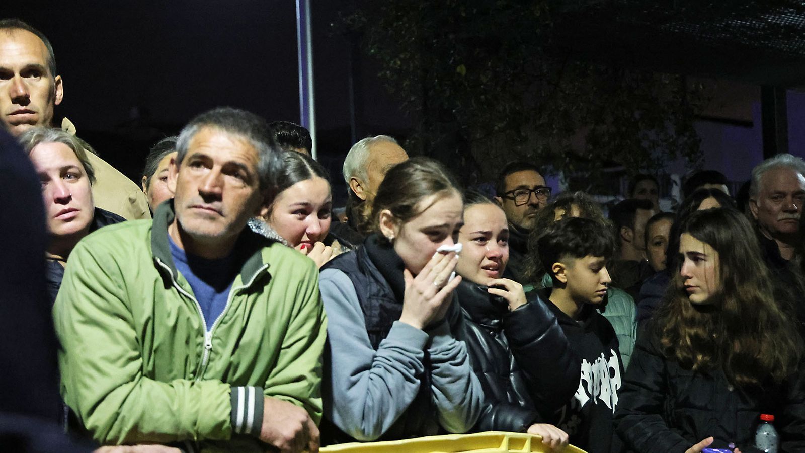 Una multitud de vecinos sin poder aguantar las lágrimas a la llegada de los féretros.