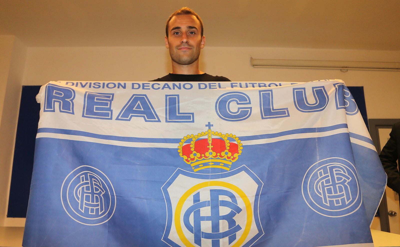Gorka Santamaría posa con una bandera del Recreativo en la sala de prensa del Nuevo Colombino, ayer.