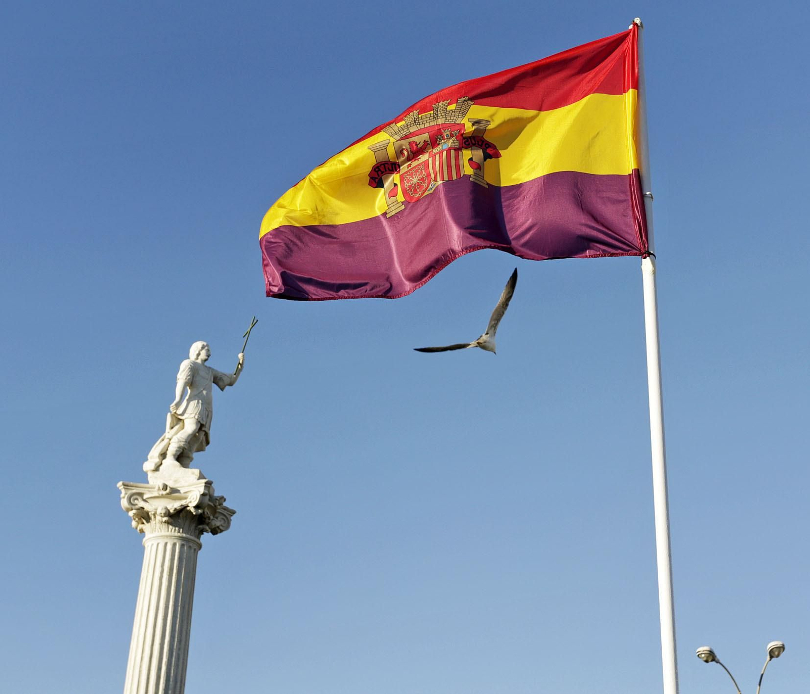 La bandera republicana ondea en la plaza de la Constitución, ante las estatuas de los patronos.