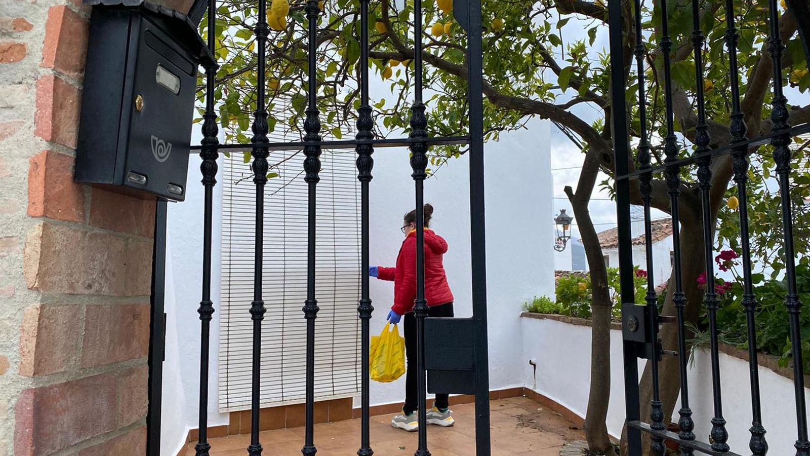 Una vecina de Genalguacil acude a llevar la compra a una anciana.