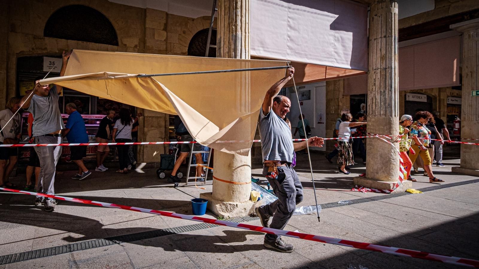 Operarios retirando uno de los viejos y deteriorados toldos de La Plaza.