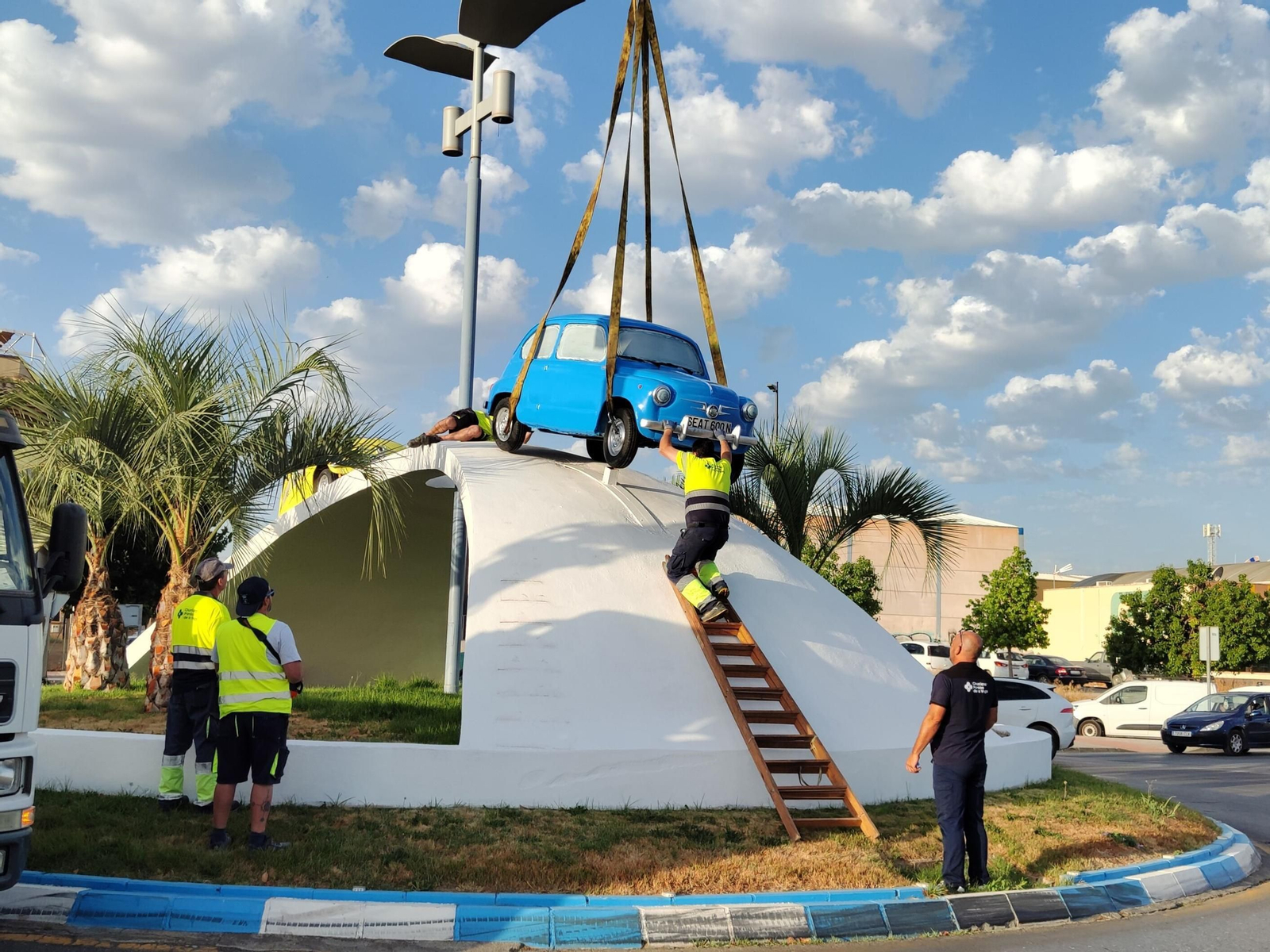 Trabajos de colocación del Seat 600 azul en la rotonda de Churriana de la Vega