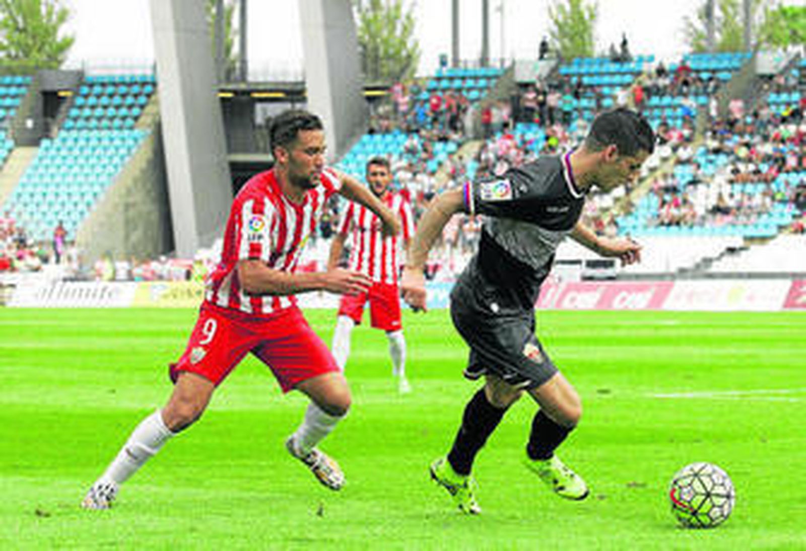 Álex Martínez conduce la pelota ante el jugador del Almería Quique en un duelo de esta pasada Liga.