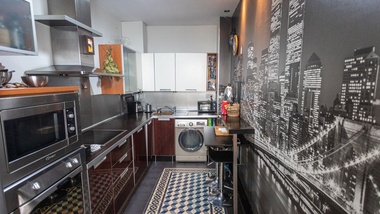 La cocina, con suelo hidráulico y un gran mural con una vista de Nueva York, a la derecha.