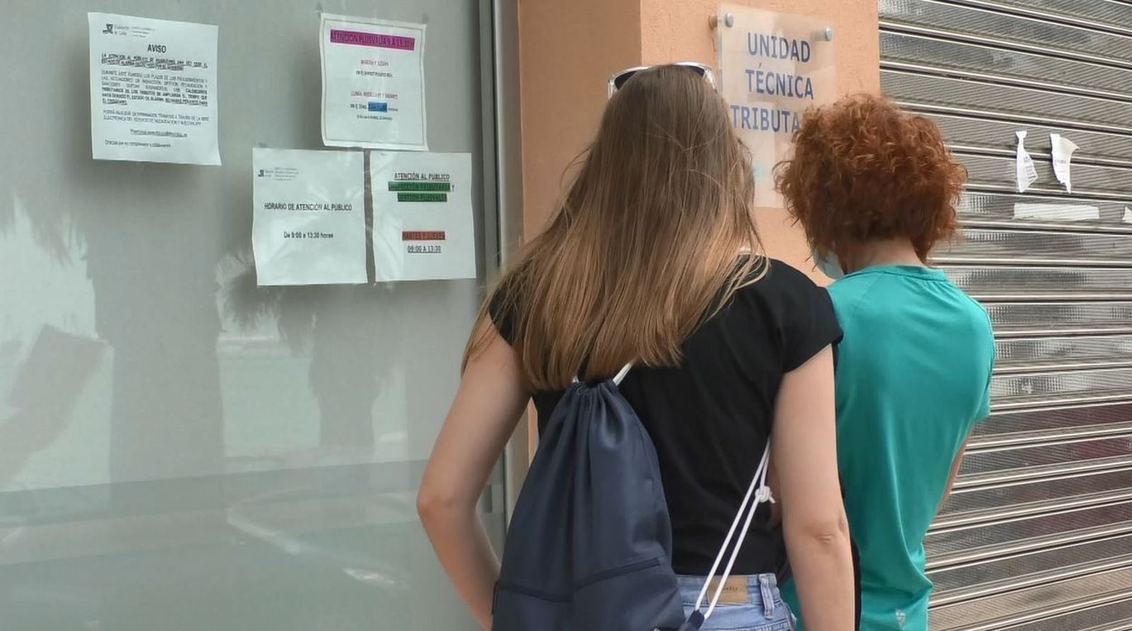 Dos personas buscan información en la Oficina de Racaudación que sigue cerrada