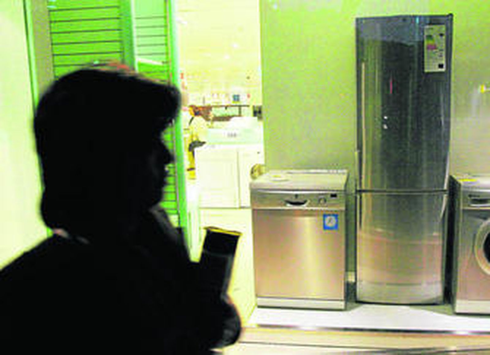 Una mujer observa el escaparate de una tienda de electrodomésticos.