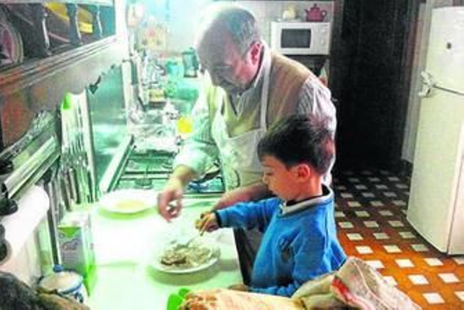 Antonio Zapata junto a su nieto Ángel preparando torrijas en su cocina.