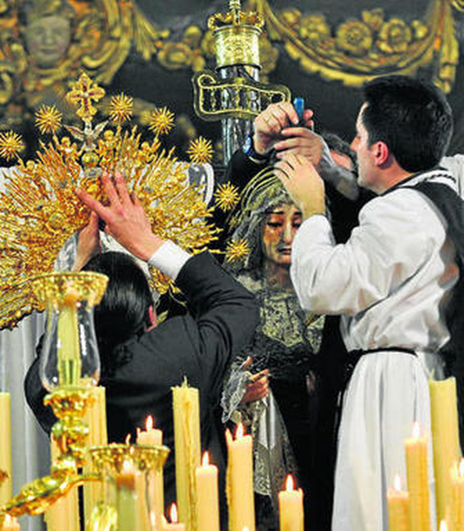 Varios hermanos intentando arreglar el perno de la diadema de la Virgen.