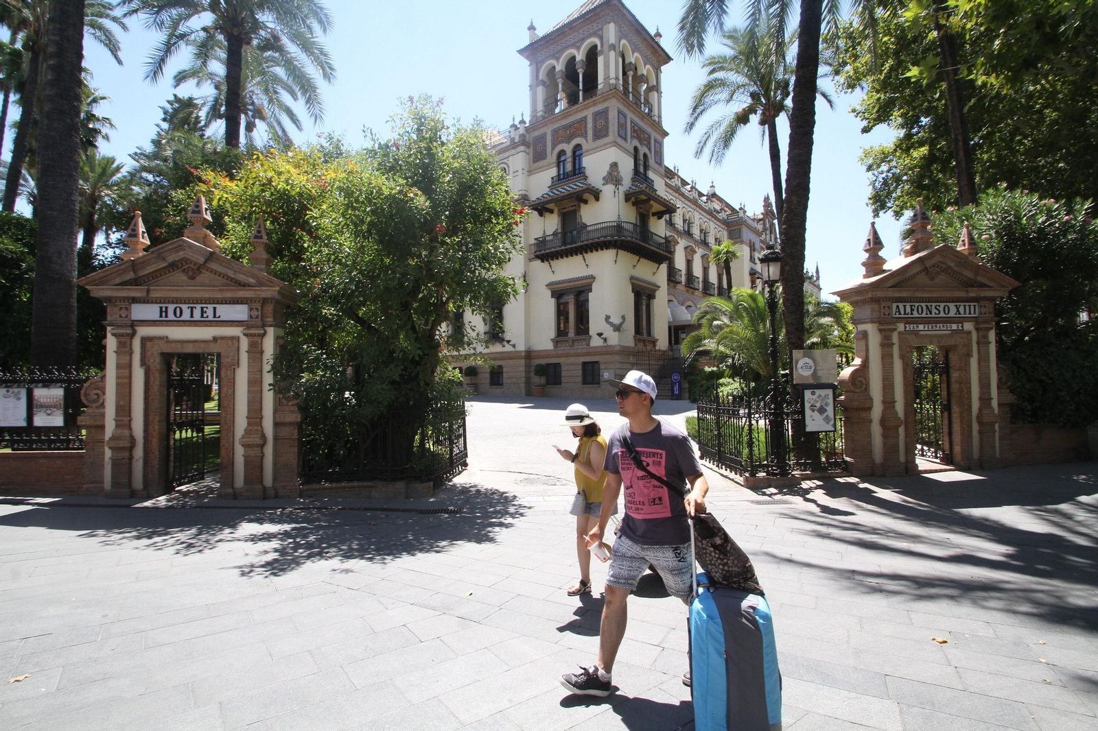 Turistas, el pasado mes de agosto, pasan ante un establecimiento hotelero en Sevilla.