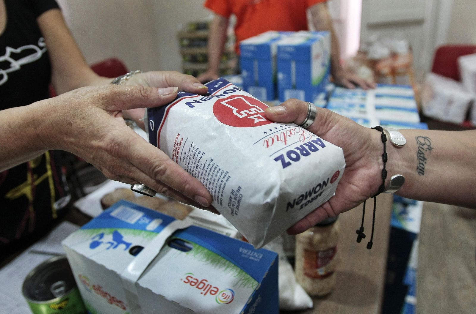 Entrega de alimentos a usuarios de un comedor social de Cádiz.