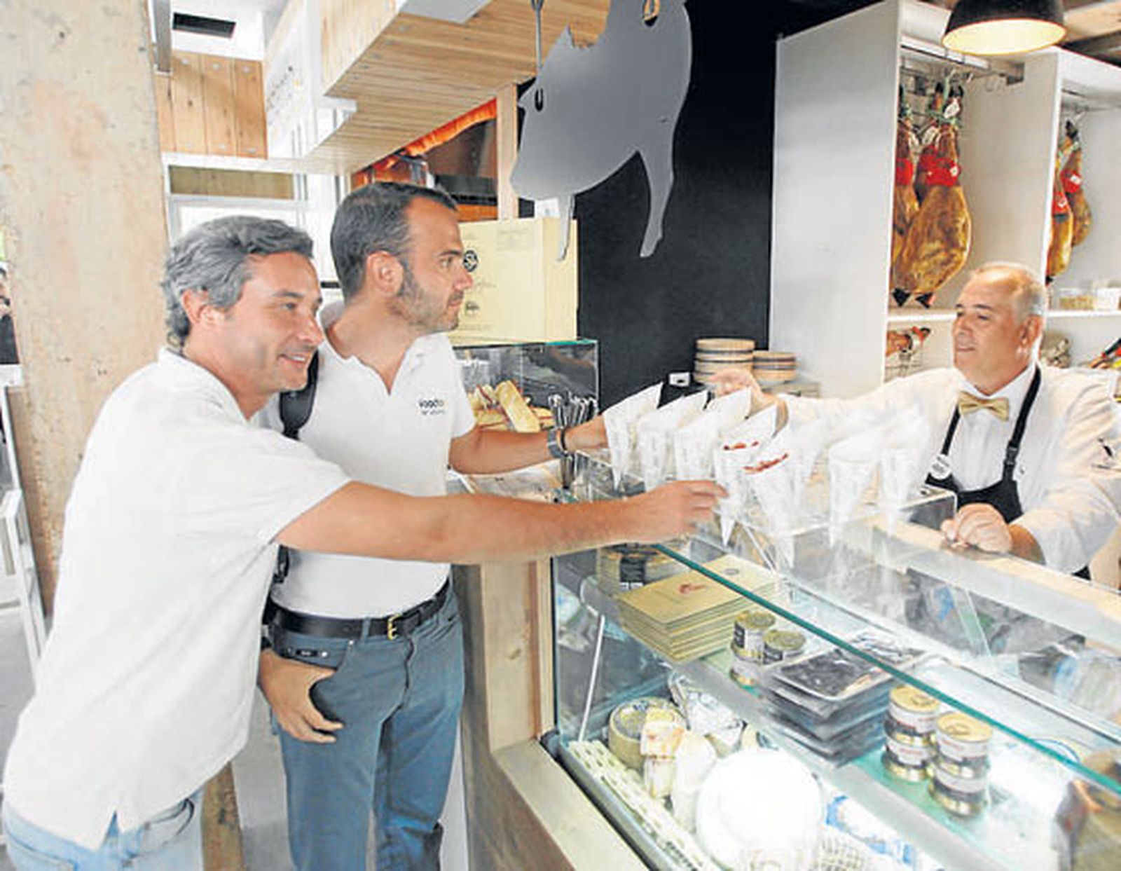 Unos clientes en el puesto de Patané Bocados Ibéricos.

Foto: José Martínez