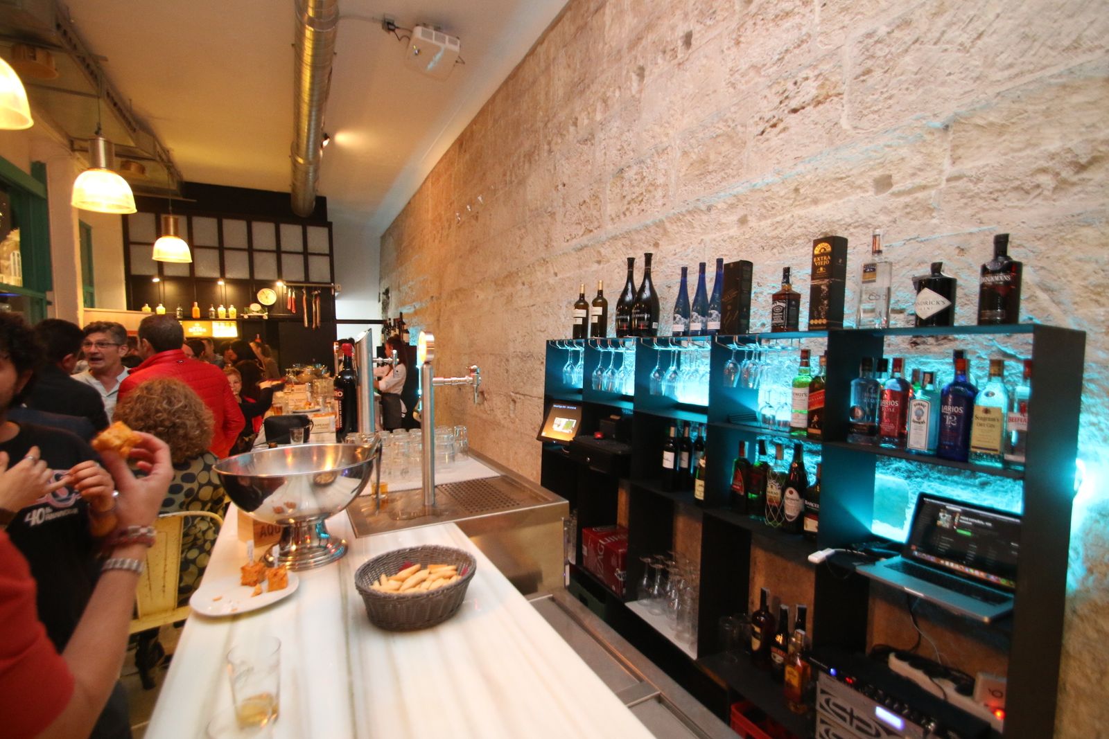 Interior del bar con la muralla tras la barra.