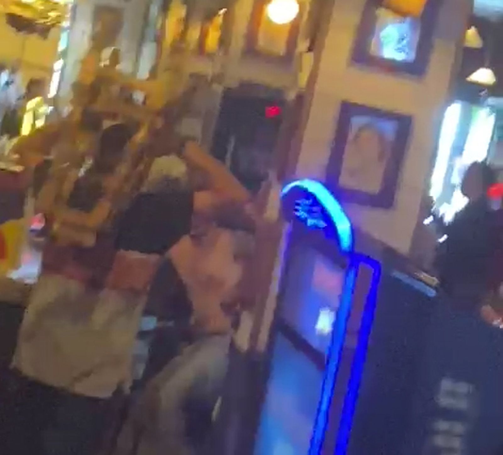 Uno de los implicados levanta una silla para golpear a otro.