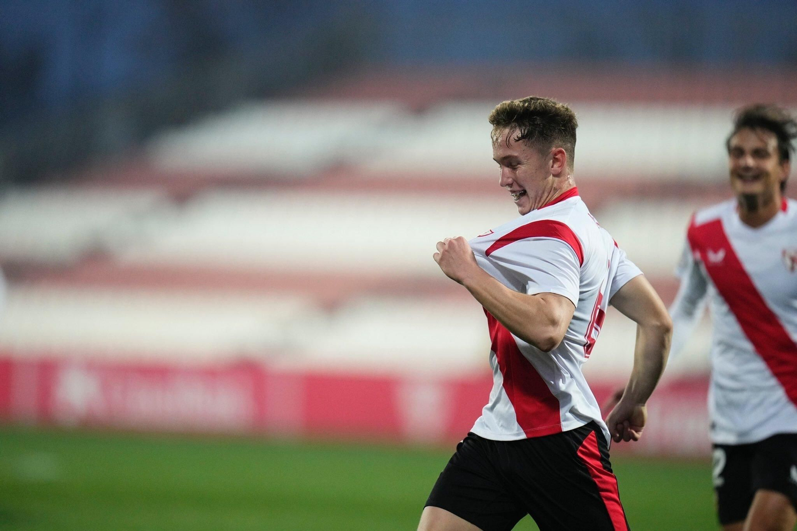 Isra se señala el escudo tras marcar en su estreno con el Sevilla Atlético.