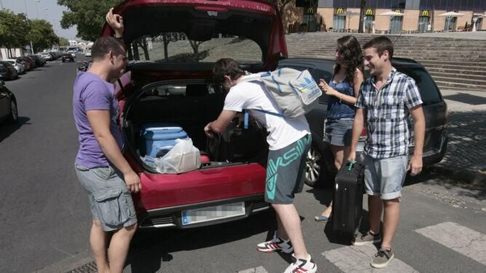 Un grupo de jóvenes cargan su equipaje en un coche compartido por la app Blablacar